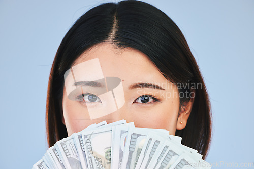 Image of Money, beauty and woman cover face on blue background for winning, cash fan or financial prize. Lottery, portrait and asian person or winner with bonus, cosmetics secret or finance profit in studio