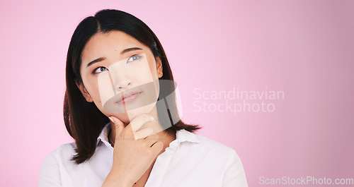 Image of Asian woman, thinking and decision on mockup space in problem solving against a pink studio background. Female person with idea, solution or choice in memory, reminder or brainstorming on mock up