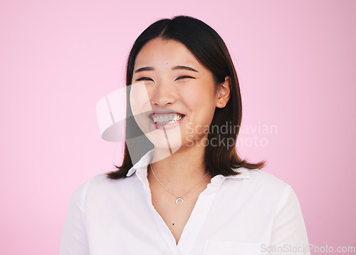 Image of Portrait, happy and asian woman laugh in studio with funny, joke or silly humor on pink background. Comic, smile and face of female model laughing to goofy, comedy or playful, good mood or positivity