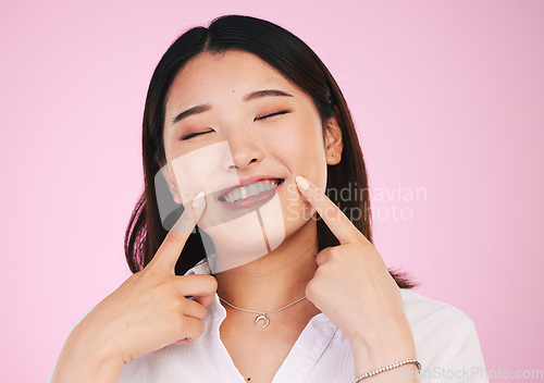 Image of Asian woman, face and hands on smile for teeth, whitening and dental wellness or beauty on pink background in studio. Tooth, care and portrait of model with happiness for cosmetics and dentistry