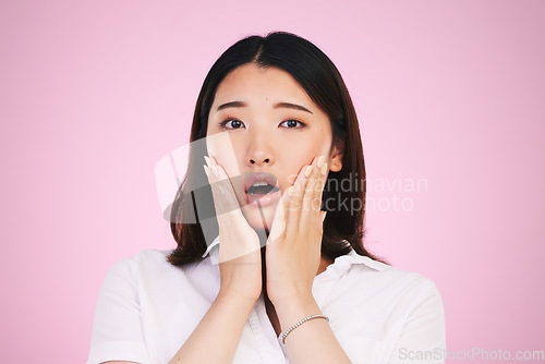 Image of Surprise, wow and hands on woman face in studio with anxiety for fake news, drama or secret on pink background. Omg, portrait and Japanese female model shocked by gossip, announcement or emoji info