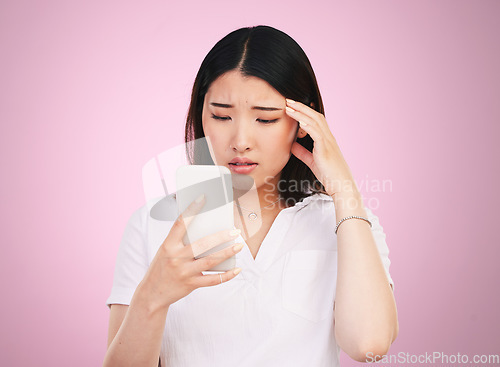 Image of Search, phone and stress with face of woman in studio for networking, communication and worry. Social media, news and frustrated with asian person on pink background for technology and mobile app