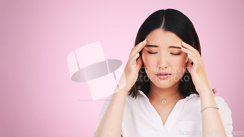 Image of Asian woman, headache and stress in anxiety, burnout or tired against a pink studio background. Frustrated, upset or unhappy female person with migraine, injury or mental health pain on mockup space