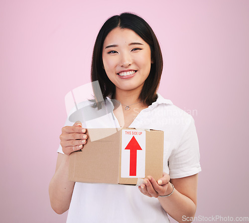 Image of Woman, box and delivery, courier and e commerce with portrait and package isolated on pink background. Asian customer, commercial and supply chain with shipping, parcel and export service in studio