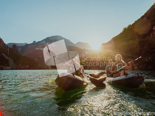 Image of A group of friends enjoying fun and kayaking exploring the calm river, surrounding forest and large natural river canyons during an idyllic sunset.