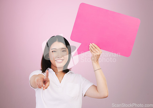 Image of Asian woman, speech bubble and pointing to you on mockup space in choice against a pink studio background. Portrait of female person shape, icon or symbol in decision, selection or vote on mock up