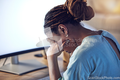 Image of Business woman, tired and stress at computer in an office at night while working late on deadline. African entrepreneur person with hands on head for pain, burnout or depression and fatigue at work