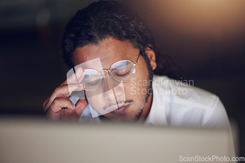 Image of Businessman, headache and stress at computer at night in office working late on deadline. Tired entrepreneur person with glasses and hands on head for pain, burnout or depression and fatigue at work