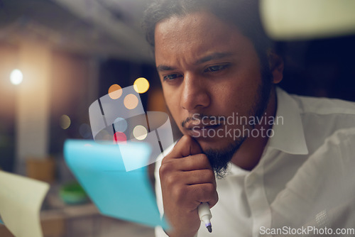 Image of Businessman, thinking and reading a note in office at night for planning a marketing strategy for professional startup in Egypt. Man, working and idea for corporate company, workplace or overtime