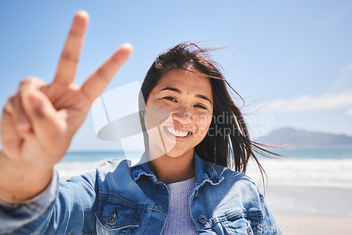 Image of Portrait, woman and sign for peace on beach, holiday or profile picture from vacation in Indonesia on summer or break. Happy, face and smile at the ocean, sea or person travel in nature with freedom