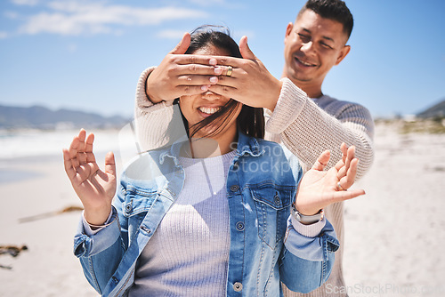 Image of Surprise, cover eyes and couple on beach with news, love and romantic date, travel and summer outdoor. Man, woman and marriage, secret announcement and bonding, adventure and vacation in Mexico