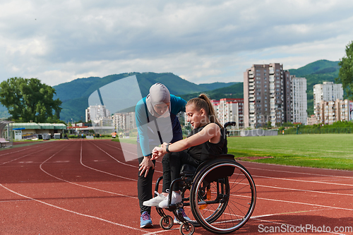 Image of A woman with disability in a wheelchair talking with friend after training on the marathon course