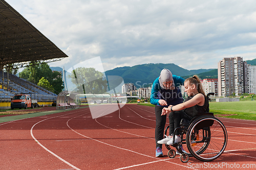 Image of A woman with disability in a wheelchair talking with friend after training on the marathon course