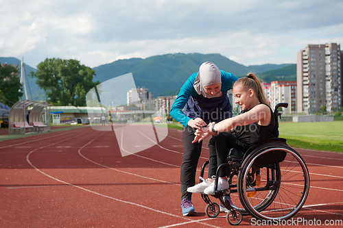 Image of A woman with disability in a wheelchair talking with friend after training on the marathon course