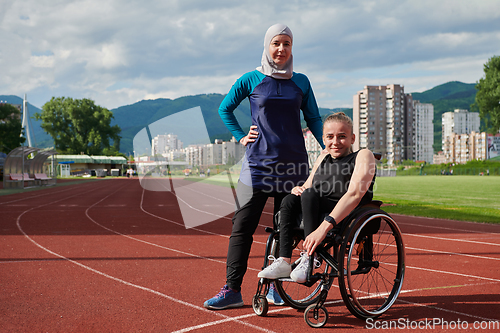 Image of A Muslim woman wearing a burqa resting with a woman with disability after a hard training session on the marathon course