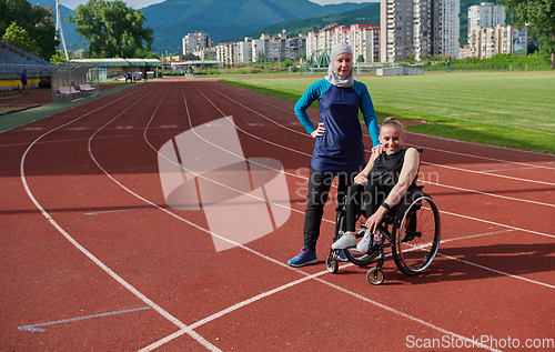 Image of A Muslim woman wearing a burqa resting with a woman with disability after a hard training session on the marathon course