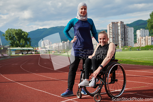 Image of A Muslim woman wearing a burqa resting with a woman with disability after a hard training session on the marathon course