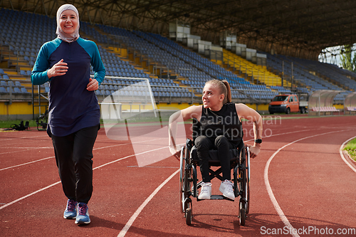 Image of A Muslim woman in a burqa running together with a woman in a wheelchair on the marathon course, preparing for future competitions.