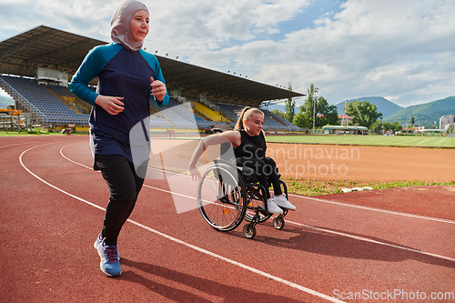 Image of A Muslim woman in a burqa running together with a woman in a wheelchair on the marathon course, preparing for future competitions.