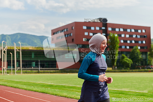 Image of A muslim woman in a burqa sports muslim clothes running on a marathon course and preparing for upcoming competitions