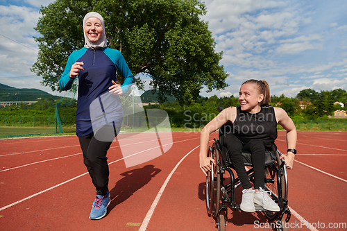 Image of A Muslim woman in a burqa running together with a woman in a wheelchair on the marathon course, preparing for future competitions.