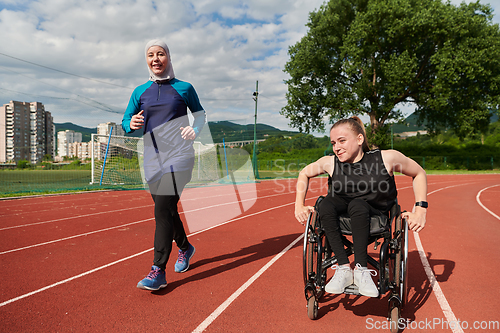 Image of A Muslim woman in a burqa running together with a woman in a wheelchair on the marathon course, preparing for future competitions.