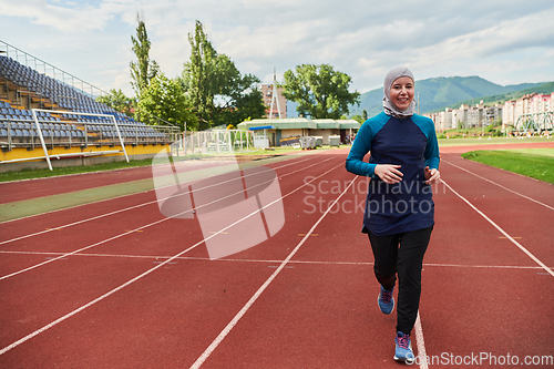 Image of A muslim woman in a burqa sports muslim clothes running on a marathon course and preparing for upcoming competitions