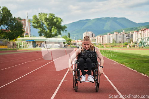 Image of A woman with disablity driving a wheelchair on a track while preparing for the Paralympic Games