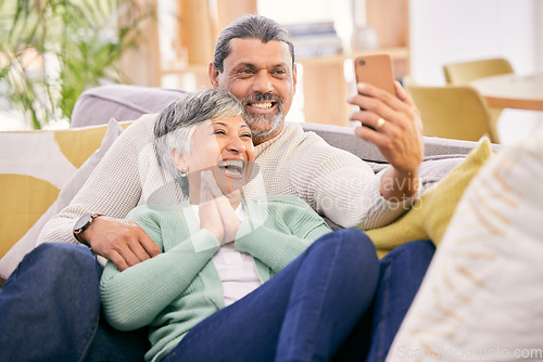 Image of Laughing, selfie and a senior couple with a phone on the sofa for communication, social media or a video call. Smile, house and an elderly man and woman taking a photo with a mobile on the couch