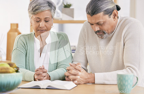Image of Praying, book and senior couple at home with bible study and religion together in marriage. Prayer, faith and elderly people with worship, learning and christian solidarity with love and care