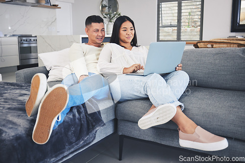 Image of Laptop, online shopping and couple relaxing on a sofa in the living room of their modern house. Happy, technology and young man and woman networking or browsing on the internet with computer at home.