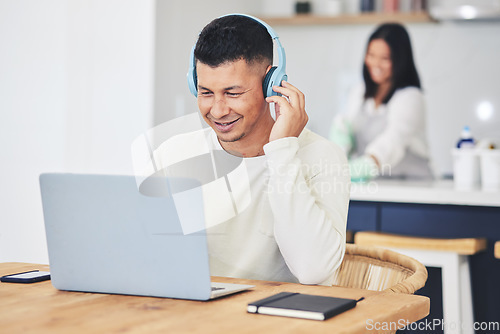 Image of Remote work from home, headphones and man with a laptop, business owner and typing with research. Person, copywriter or freelancer streaming audio, kitchen and pc with headset, project or connection