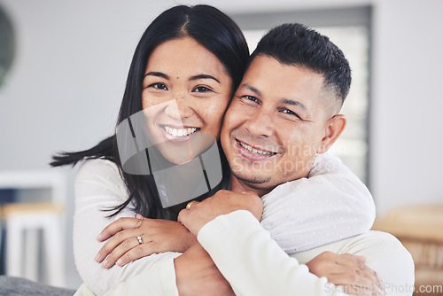 Image of Love, hug and portrait of a couple in the living room bonding together in their modern house. Happy, smile and face of young man and woman with affection while relaxing in the lounge at home.