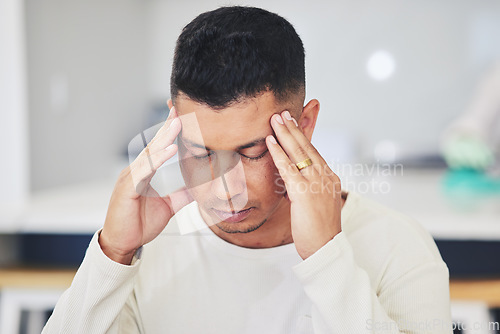 Image of Man, headache and stress in burnout, debt or financial crisis from depression, anxiety or mental health at home. Frustrated, upset or tired male person with migraine, pain or sore injury in house