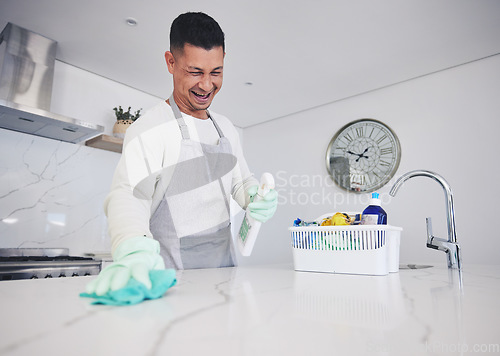 Image of Kitchen, cleaning and happy man with spray for kitchen, counter or surface care at home. Housework, spring clean and male person smile while using bacteria, dust and dirt control product in a house