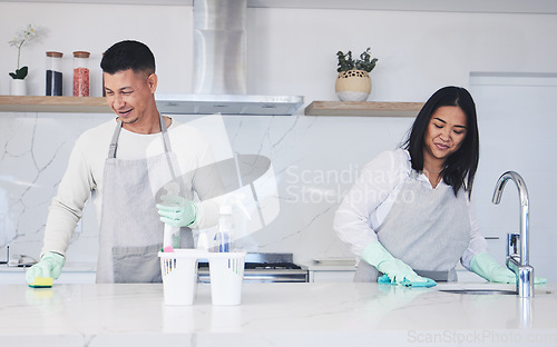 Image of Happy couple, housekeeper and cleaning table in kitchen, chemical equipment or detergent in bacteria and germ removal at home. Man and woman wiping surface with cloth together in hygiene to sanitise