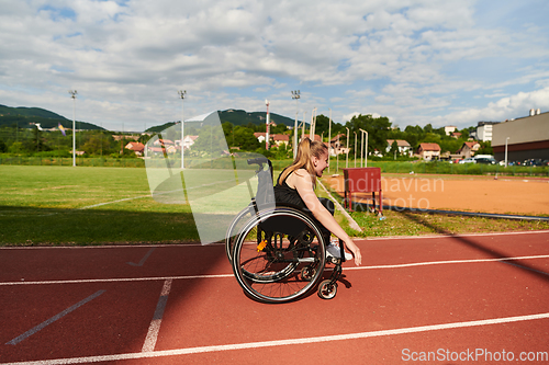 Image of A woman with disablity driving a wheelchair on a track while preparing for the Paralympic Games