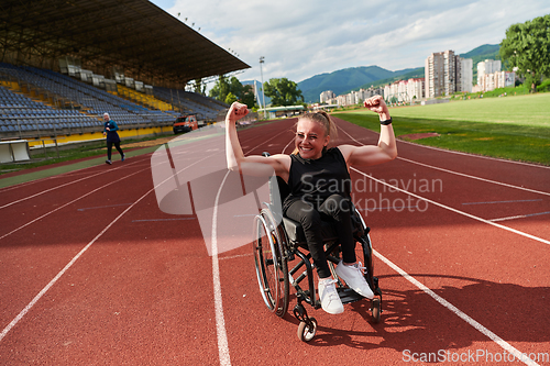 Image of A woman with disability in a wheelchair showing dedication and strength by showing her muscles