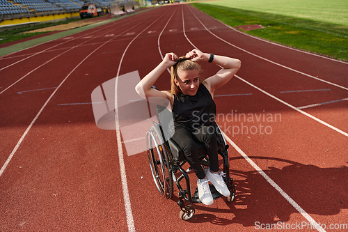 Image of A woman with disability in a wheelchair showing dedication and strength by showing her muscles