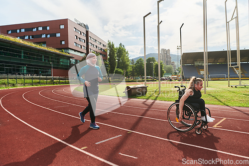 Image of A Muslim woman in a burqa running together with a woman in a wheelchair on the marathon course, preparing for future competitions.