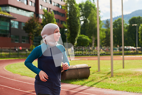 Image of A muslim woman in a burqa sports muslim clothes running on a marathon course and preparing for upcoming competitions