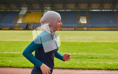 Image of A muslim woman in a burqa sports muslim clothes running on a marathon course and preparing for upcoming competitions