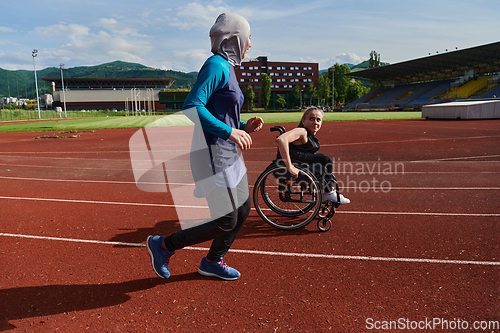 Image of A Muslim woman in a burqa running together with a woman in a wheelchair on the marathon course, preparing for future competitions.