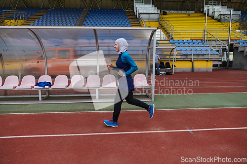 Image of A muslim woman in a burqa sports muslim clothes running on a marathon course and preparing for upcoming competitions