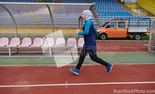 Image of A muslim woman in a burqa sports muslim clothes running on a marathon course and preparing for upcoming competitions