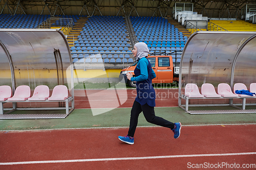 Image of A muslim woman in a burqa sports muslim clothes running on a marathon course and preparing for upcoming competitions