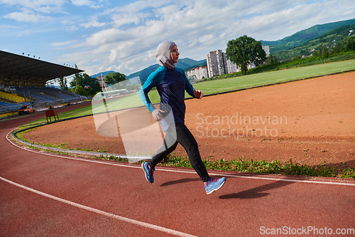 Image of A muslim woman in a burqa sports muslim clothes running on a marathon course and preparing for upcoming competitions