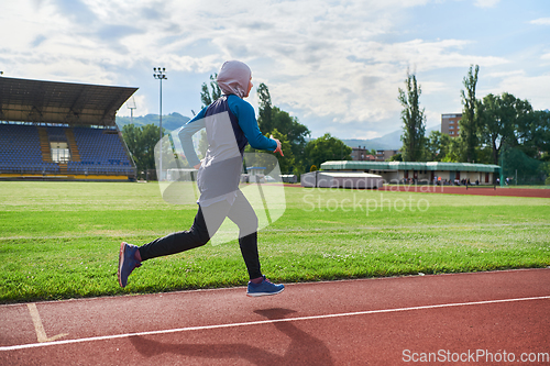 Image of A muslim woman in a burqa sports muslim clothes running on a marathon course and preparing for upcoming competitions