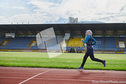 Image of A muslim woman in a burqa sports muslim clothes running on a marathon course and preparing for upcoming competitions