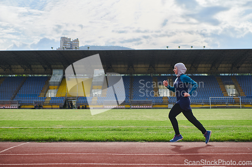 Image of A muslim woman in a burqa sports muslim clothes running on a marathon course and preparing for upcoming competitions